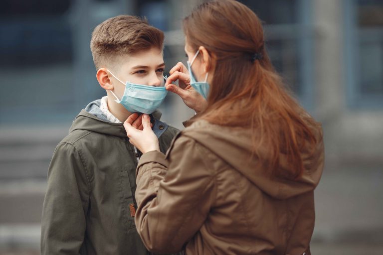 A boy and mother are wearing protective masks